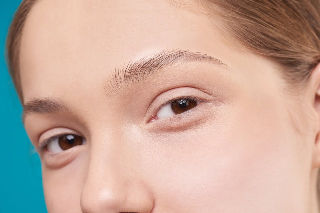 A close-up photo showcasing a woman's natural skin and eye detail, emphasizing natural beauty.
